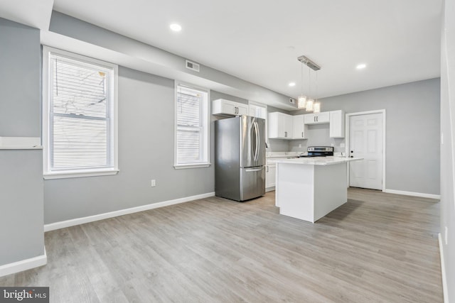 kitchen with baseboards, a center island, white cabinetry, light wood-style floors, and stainless steel appliances