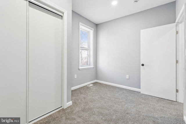 unfurnished bedroom with a closet, baseboards, and carpet floors