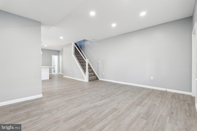unfurnished living room with light wood-type flooring, recessed lighting, and stairway