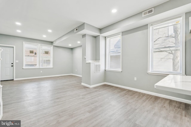 unfurnished living room featuring visible vents, light wood-style flooring, recessed lighting, and baseboards