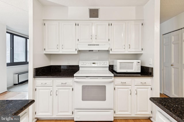 1420 Locust St Unit 6Q, Philadelphia, PA 19102 - kitchen featuring white appliances, under cabinet range hood, white cabinets, dark stone countertops, and light wood finished floors