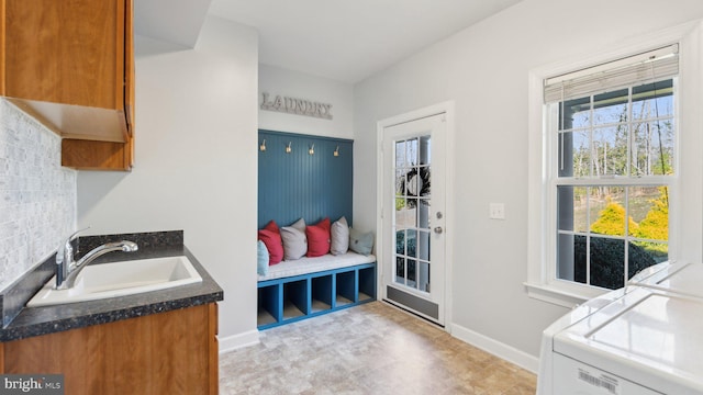 mudroom with plenty of natural light, baseboards, and a sink