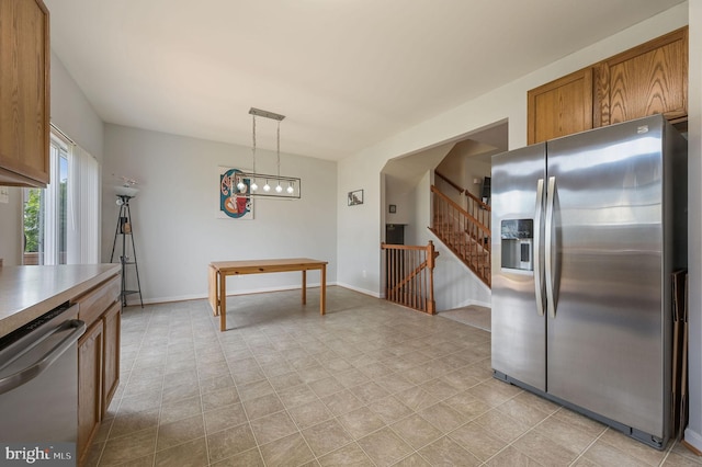 720 Birch Tree Ln, Smyrna, DE 19977 - kitchen featuring stainless steel appliances, brown cabinetry, pendant lighting, and baseboards