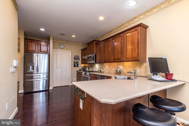 14 Komen Ct, Sellersville, PA 18960 - kitchen featuring a sink, a peninsula, stainless steel appliances, dark wood-type flooring, and decorative backsplash