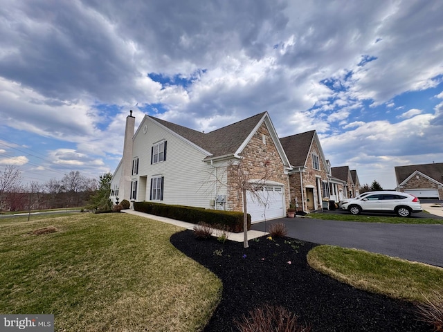 14 Komen Ct, Sellersville, PA 18960 - view of side of home featuring a yard, a chimney, a garage, and aphalt driveway