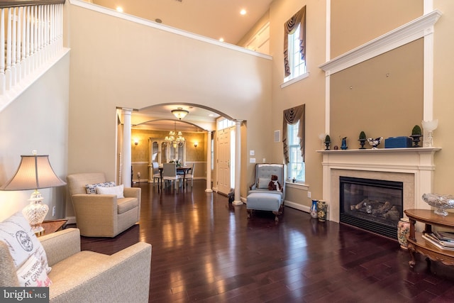 14 Komen Ct, Sellersville, PA 18960 - living area with arched walkways, ornate columns, a glass covered fireplace, hardwood / wood-style floors, and a notable chandelier