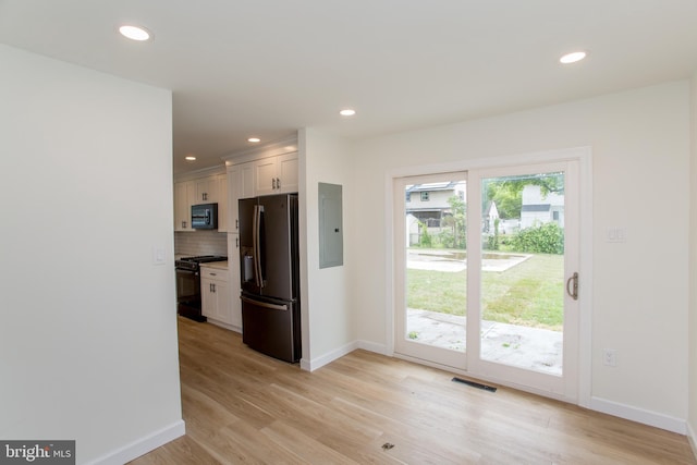 1102 Dolores Ln, Croydon, PA 19021 - kitchen with black appliances, electric panel, baseboards, tasteful backsplash, and light wood-style flooring