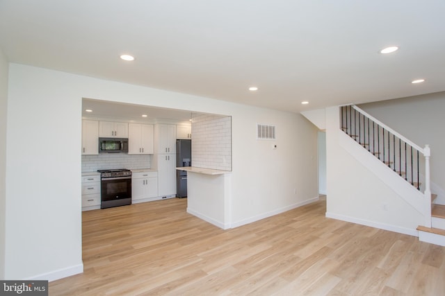 1102 Dolores Ln, Croydon, PA 19021 - kitchen featuring black microwave, stainless steel gas range oven, fridge with ice dispenser, white cabinetry, and light countertops