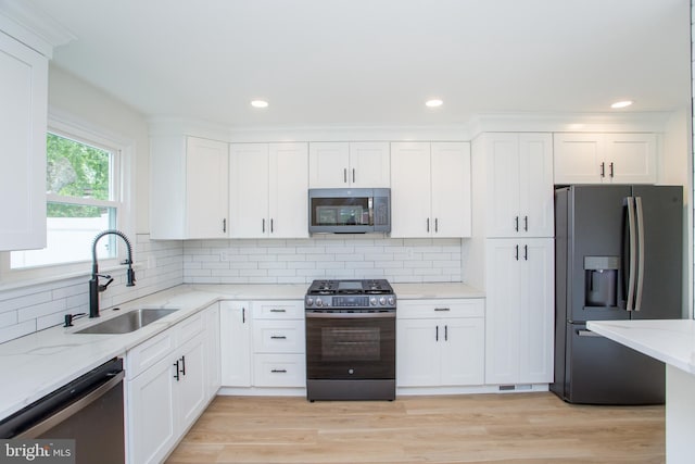 1102 Dolores Ln, Croydon, PA 19021 - kitchen with stainless steel appliances, a sink, white cabinetry, light stone countertops, and backsplash