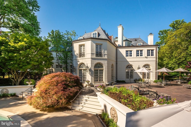 2838 Mcgill Ter NW, Washington, DC 20008 - french country home with french doors, a patio, a high end roof, a chimney, and stairway