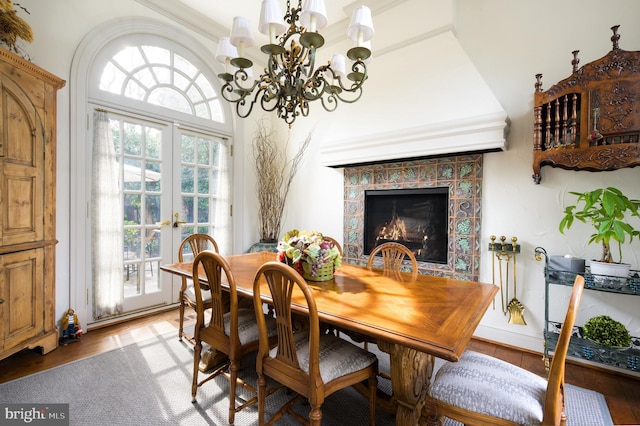 2838 Mcgill Ter NW, Washington, DC 20008 - dining area with wood finished floors, a chandelier, a tiled fireplace, and french doors