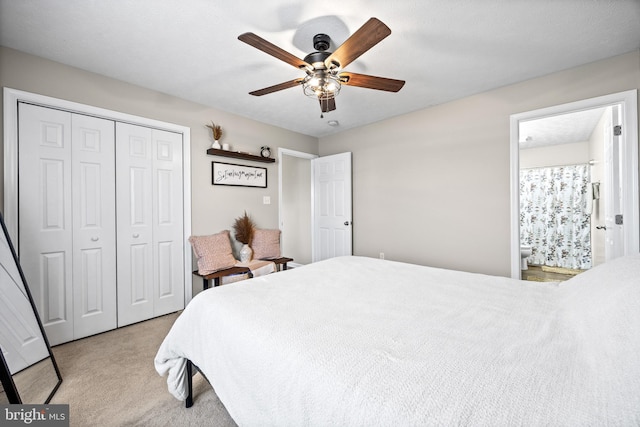 bedroom featuring a closet, carpet flooring, ensuite bathroom, and a ceiling fan