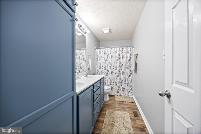 full bath with toilet, a textured ceiling, a sink, visible vents, and wood finished floors