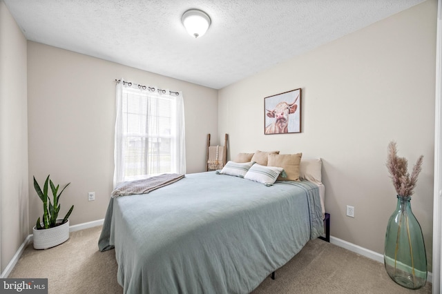 bedroom with baseboards, carpet floors, and a textured ceiling
