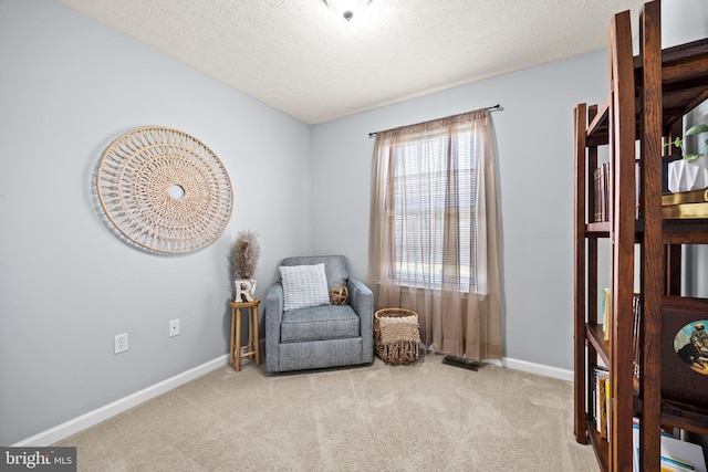 living area featuring baseboards, carpet floors, a textured ceiling, and visible vents