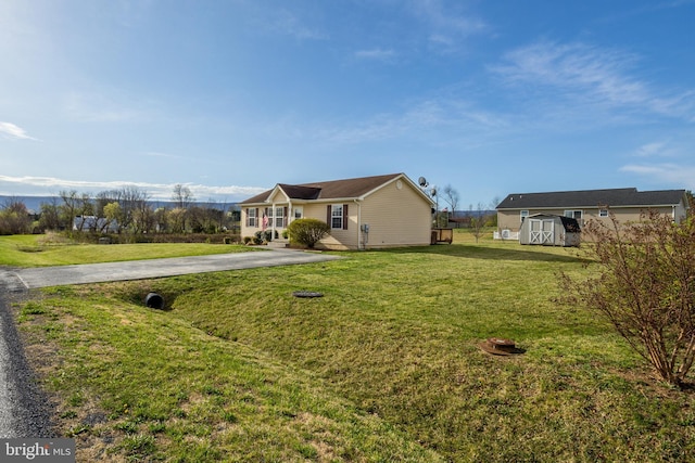 exterior space with an outdoor structure, driveway, and a storage shed
