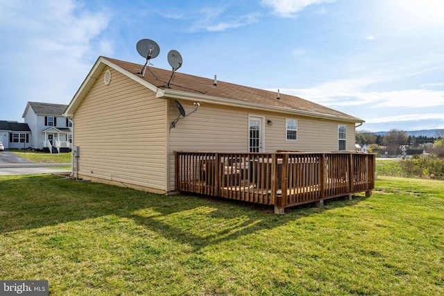 back of property with a wooden deck and a yard