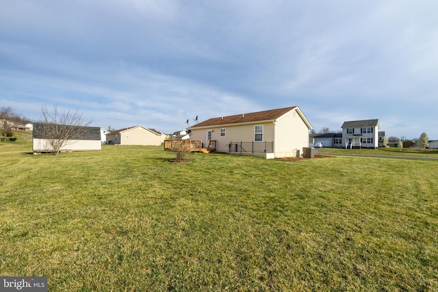 view of yard with a wooden deck, an outdoor structure, and central AC