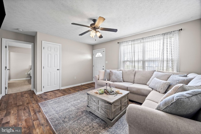 living room with dark wood-style floors, baseboards, a textured ceiling, and ceiling fan