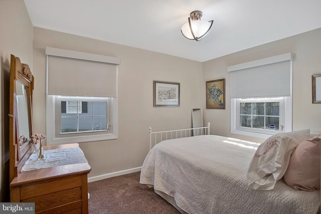 bedroom featuring dark carpet and baseboards