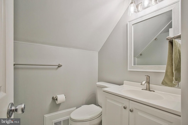 half bathroom featuring vanity, visible vents, toilet, and lofted ceiling