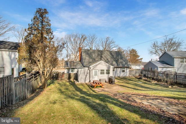 back of house with a fenced backyard, a patio, a lawn, and a chimney
