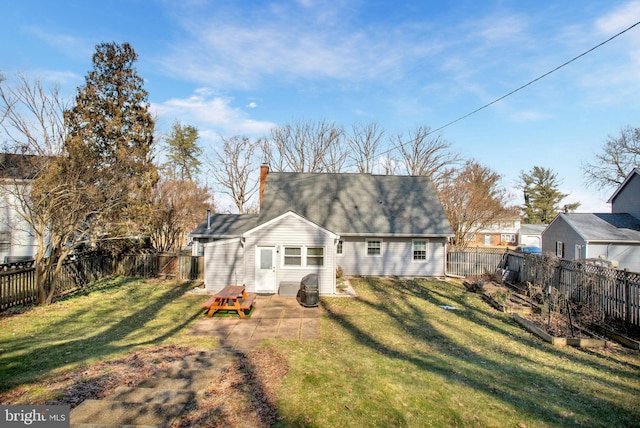 rear view of house featuring a patio area, a fenced backyard, a chimney, and a lawn