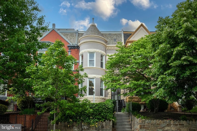 victorian house with stairs and a high end roof