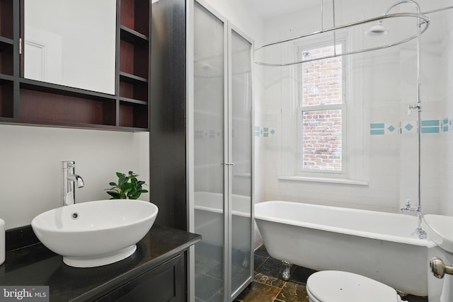 bathroom with vanity, a freestanding bath, toilet, and a shower