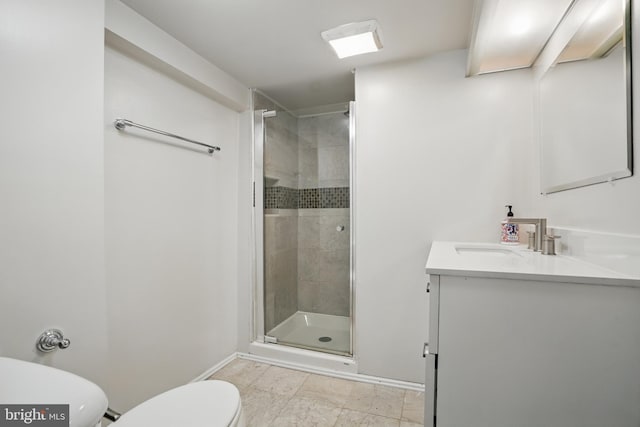 bathroom with toilet, a shower stall, vanity, and baseboards