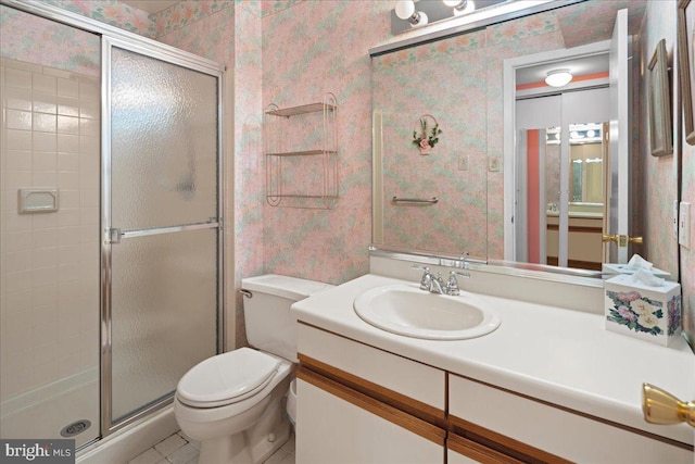 bathroom featuring vanity, toilet, a stall shower, and wallpapered walls