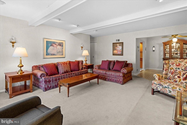 carpeted living area featuring visible vents, beam ceiling, ceiling fan, and baseboards