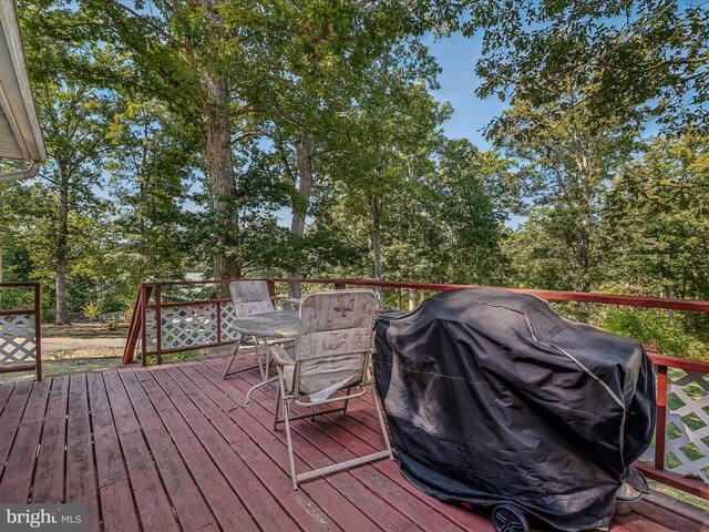 deck featuring outdoor dining area and grilling area