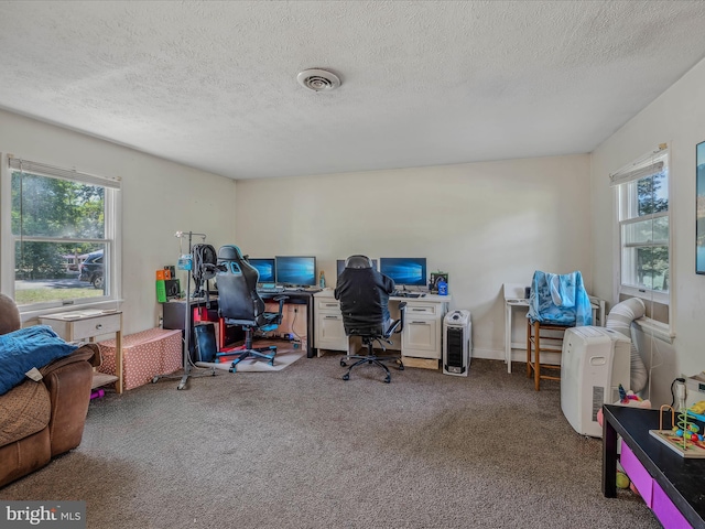 home office featuring carpet flooring, a textured ceiling, and visible vents