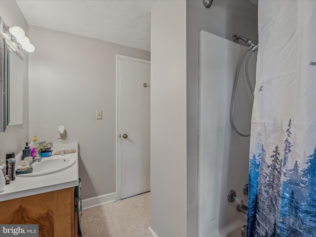 bathroom with vanity, baseboards, and a textured ceiling