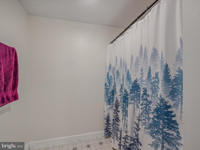bathroom with baseboards and a textured ceiling