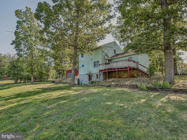 rear view of house with a lawn, a deck, and stairway