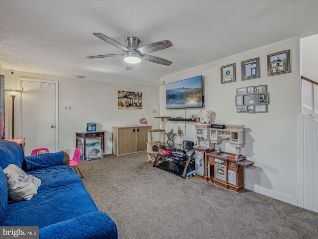 carpeted living room featuring a textured ceiling, baseboards, and a ceiling fan