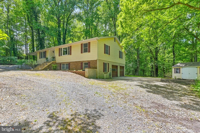 7000 Burch Hill Rd, Brandywine, MD 20613 - bi-level home with gravel driveway, a garage, and view of wooded area