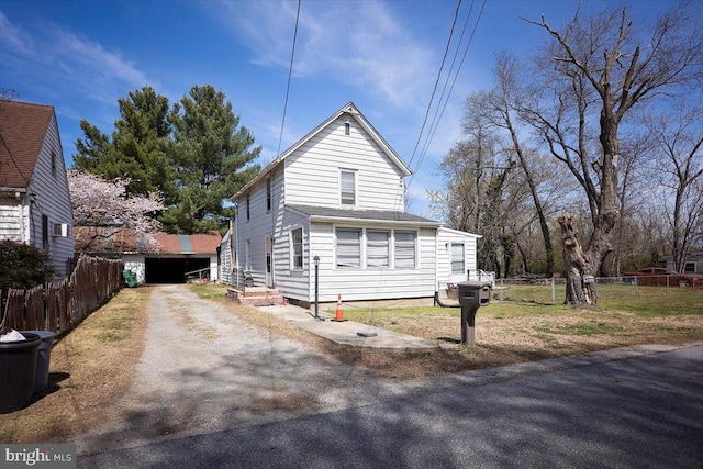 view of front facade featuring driveway, a garage, and fence