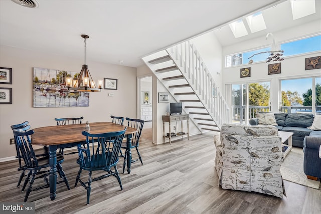 dining room with baseboards, stairs, wood finished floors, and a notable chandelier