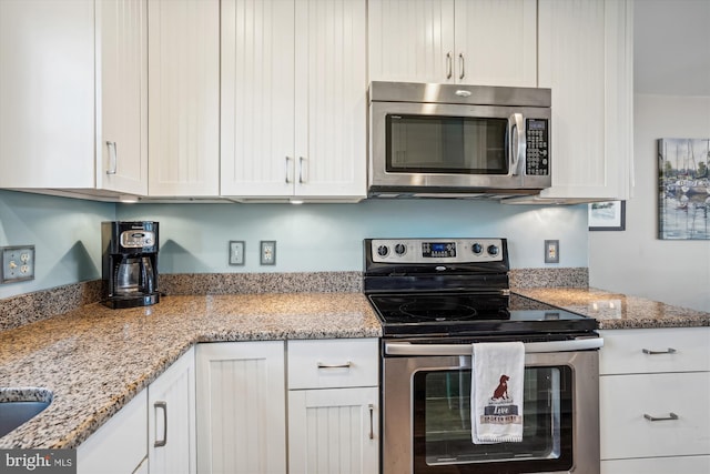 kitchen featuring white cabinetry, light stone countertops, and appliances with stainless steel finishes