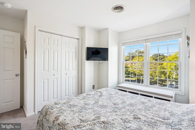 bedroom featuring visible vents, a closet, and carpet