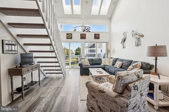living room with a healthy amount of sunlight, stairs, and wood finished floors