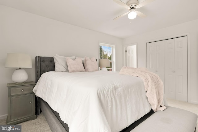 bedroom with a ceiling fan, a closet, and light colored carpet
