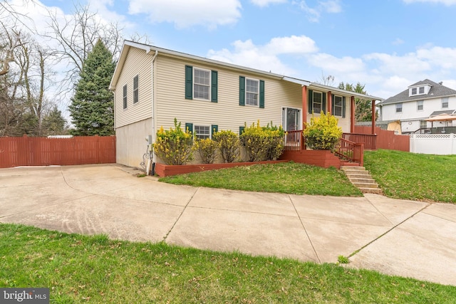 split foyer home with fence and a front lawn