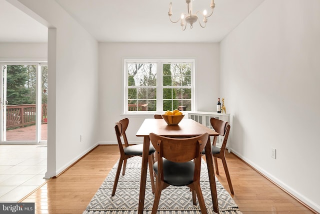 dining room featuring plenty of natural light, light wood-type flooring, and an inviting chandelier