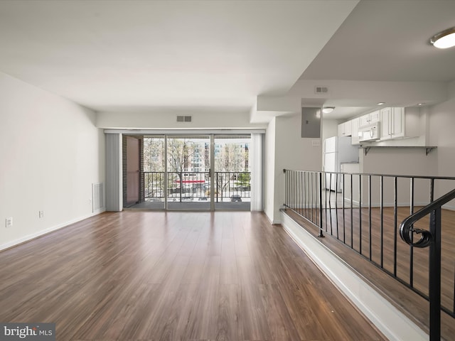 spare room with dark wood finished floors, baseboards, and visible vents