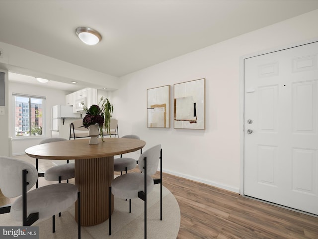 dining area with baseboards and wood finished floors