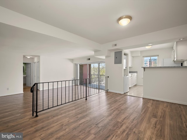 interior space featuring baseboards, visible vents, a wealth of natural light, and wood finished floors